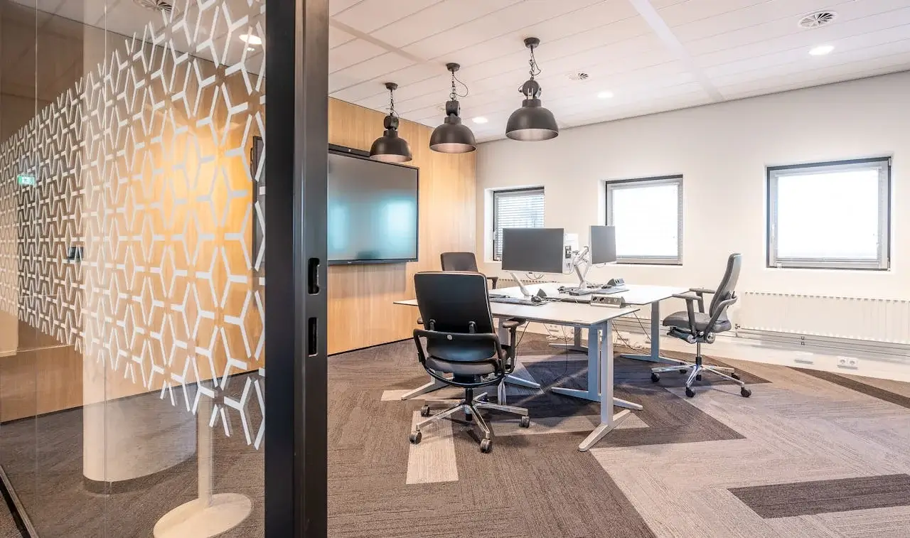 Moderne Büroeinrichtung mit klaren Linien, ergonomischen Stühlen und geometrischen Trennwänden